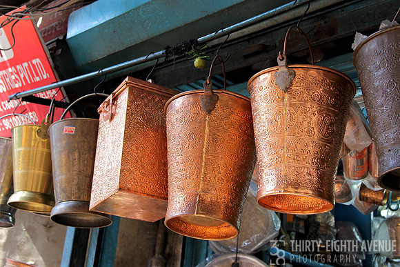Bright Copper Buckets Hanging In Store Entry Way
